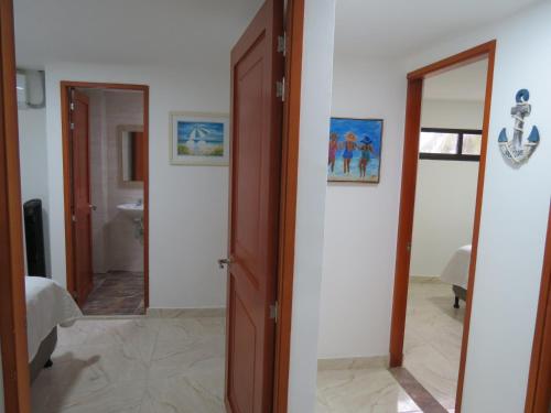 um corredor com uma porta que leva a uma casa de banho em ZOJO MARiNA BAY em San Andrés