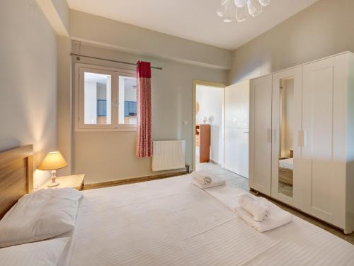 a bedroom with a large white bed and a window at Casa Fabrica in Ano Syros
