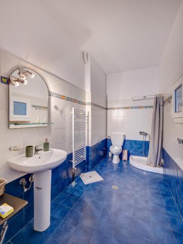 a blue and white bathroom with a sink and a toilet at Casa Fabrica in Ano Syros