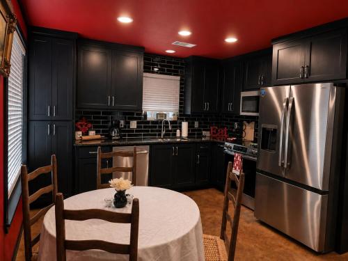 a kitchen with a table and a stainless steel refrigerator at Toad-Ally Cozy Cottage - Conway Getaway in Conway