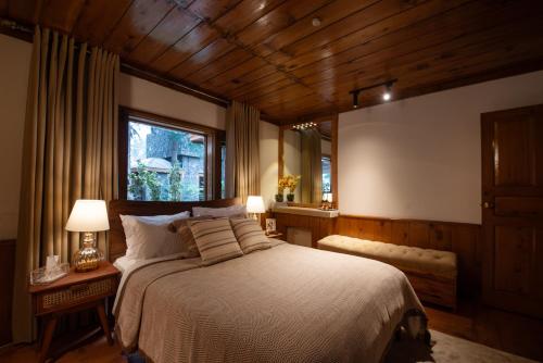 a bedroom with a large bed and a window at Secret Garden Kalam in Kalām