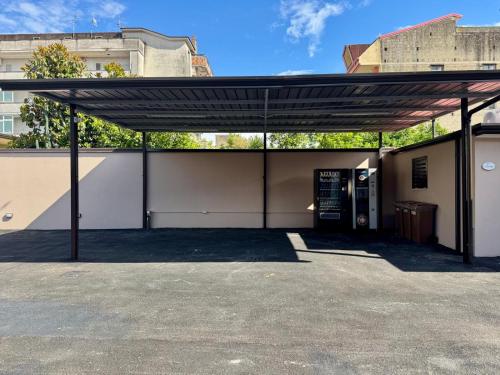 a building with awning in a parking lot at PAMA Home in Acerra