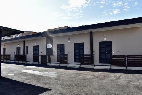 a white building with black shutters on it at PAMA Home in Acerra
