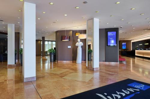 a lobby with a statue in the middle of a building at Radisson Blu Sobieski in Warsaw