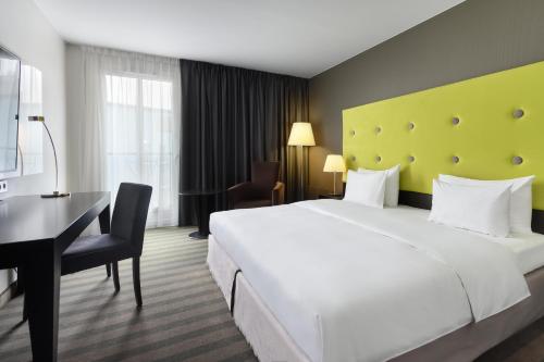 a hotel room with a large white bed and a desk at Radisson Blu Sobieski in Warsaw