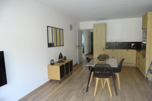 a dining room with a table and chairs in a room at Escapade Bassin - Spa Privé - Maison 6 Pers in Audenge