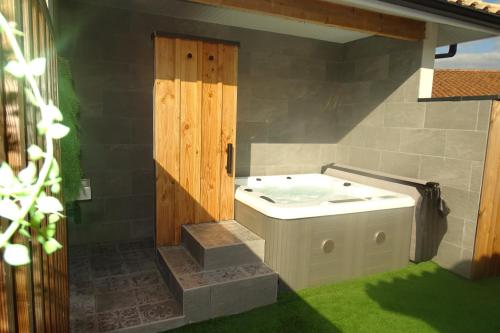 a bathroom with a tub in a room with grass at Escapade Bassin - Spa Privé - Maison 6 Pers in Audenge