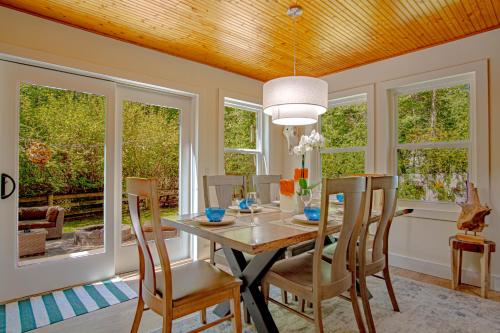 a dining room with a table and chairs and windows at Red Elephant | 4BR - Fire Pit - River & Downtown in Hailey