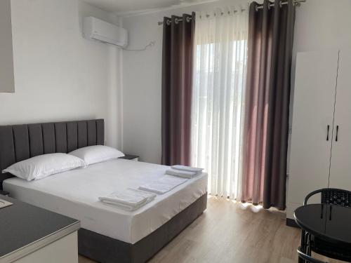 una camera da letto con un letto e una grande finestra di Arval Rooms a Vlorë