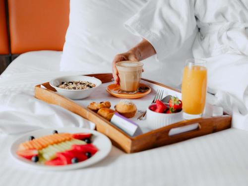 ein Tablett mit Essen auf dem Bett zum Frühstück in der Unterkunft Mercure Sydney Parramatta in Sydney