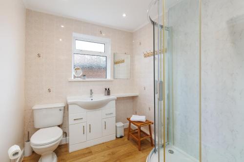 a bathroom with a toilet and a sink and a shower at Westway - 3 Bed Coastal Bungalow with Large Garden Steps from Colwell Bay Beach in Freshwater