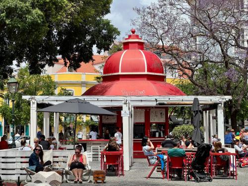 a group of people sitting at tables in a gazebo at Studios with Mezzanine Rua da Moeda in Lisbon