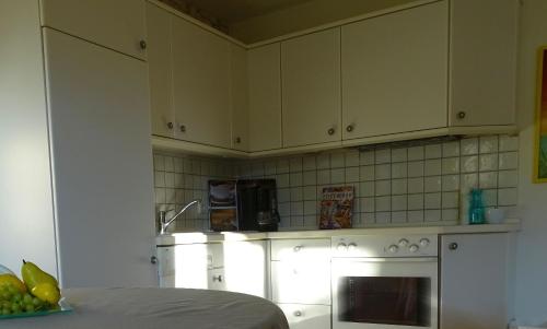 a kitchen with white cabinets and an oven at Ferienwohnung findus in Haldenwang