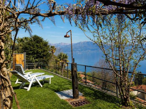 a patio with a bench and a view of a lake at Casa Coccinella in Oggebbio