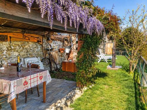 a garden with a table and purple wisteria at Casa Coccinella in Oggebbio