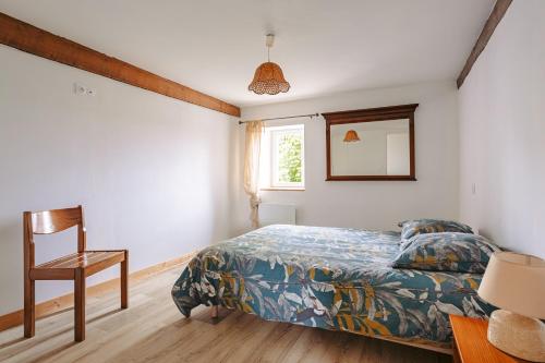 a bedroom with a bed and a chair and a window at Gîte Les Bougrines - Marais in Fontaines