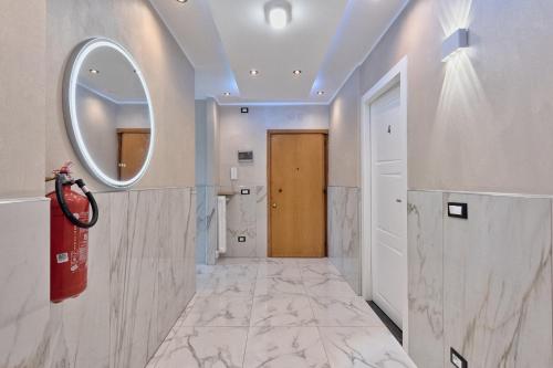 a bathroom with a mirror and a hallway with marble floors at Sara Venice station in Mestre
