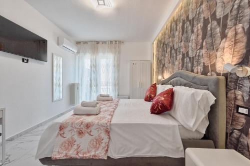 a bedroom with a large bed with red pillows at Sara Venice station in Mestre