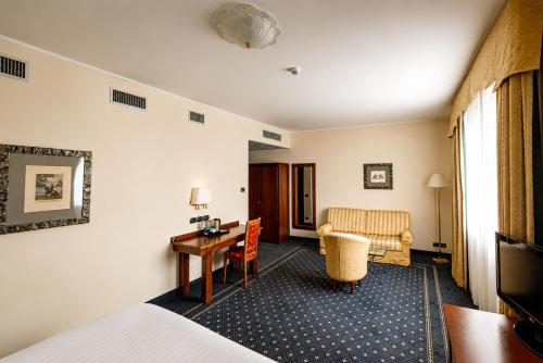ein Hotelzimmer mit Bett und Schreibtisch in der Unterkunft Phi Hotel Cavalieri in Bra