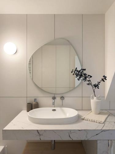 a white bathroom with a sink and a mirror at Cozyhouse in Slavske