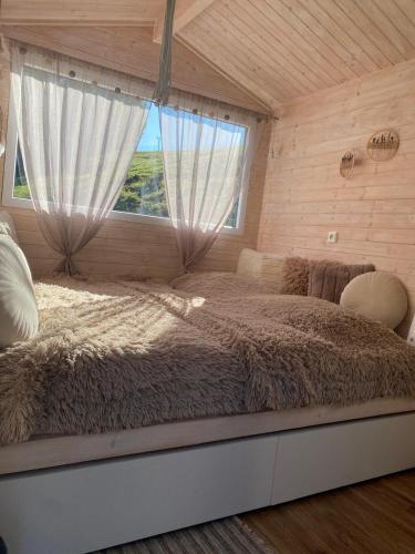 a bedroom with a large bed with a window at Tinyhouse Cecilka in Ústí nad Orlicí