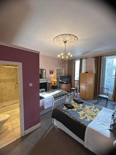 a hotel room with two beds and a chandelier at IVY- Braveheart Guest House in Edinburgh