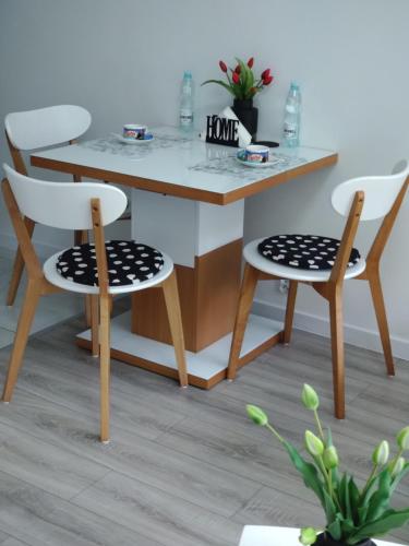a table with two chairs and a table with a table at MG Apartament Elfów in Tychy