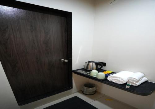 a room with a door and a shelf with towels at TheCloud Hotel in Nizāmābād