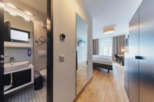 a bathroom with a sink and a toilet in a room at Montfort - das Hotel in Feldkirch