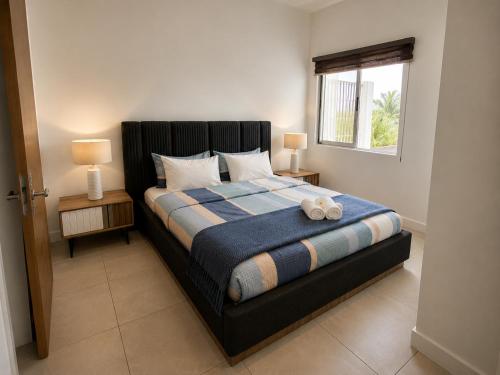 a bedroom with a bed with two lamps and a window at Seaside Escape with Breathtaking View in Grande Gaube