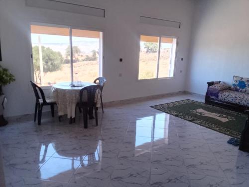 a living room with a table and a couch at Tigmi Nrayss in Essaouira