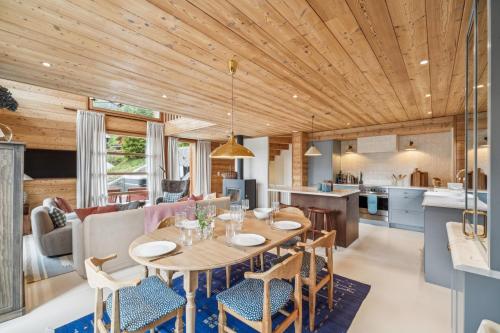 a kitchen and living room with a wooden ceiling at Chalet SkyLodge by Mrs Miggins in Grimentz