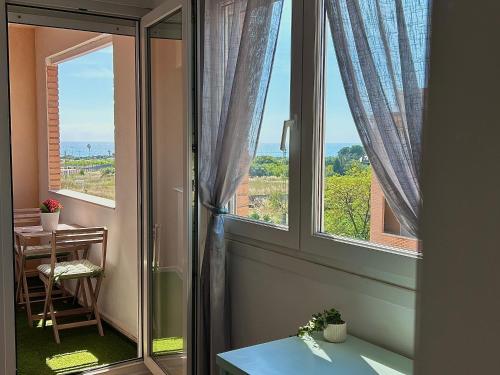 a room with a window with a table and a table sidx sidx at Baires&Blo Ático duplex, Terraza chillout exclusiva y vistas al mar in Benicarló