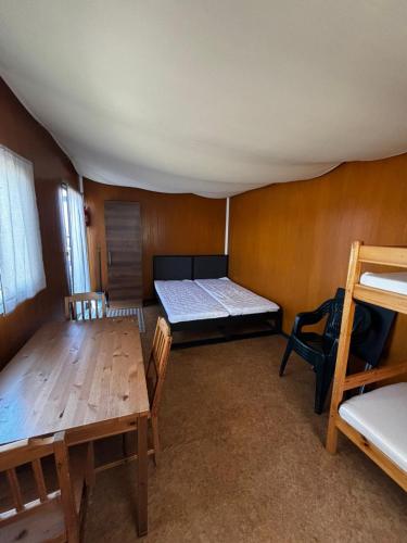 a room with a bed and a table and chairs at Domki Letniskowe Vertigo Narie in Morąg