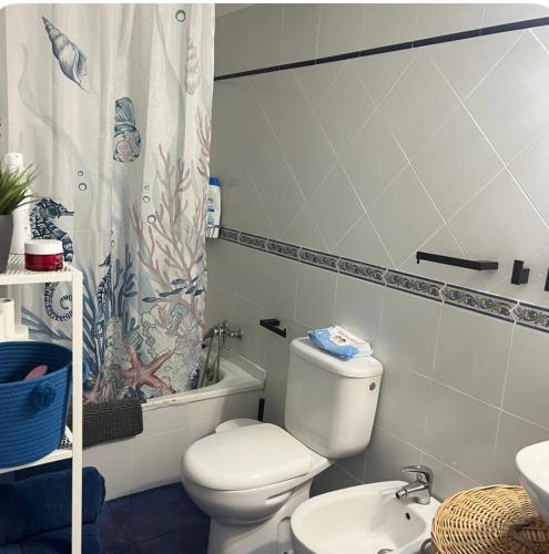 a bathroom with a toilet and a shower curtain at Villa guiris in Barbate