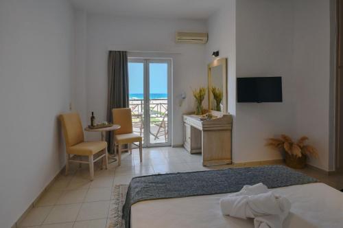 a bedroom with a bed and a desk and a television at Naiades Hotel by Estia in Kato Gouves
