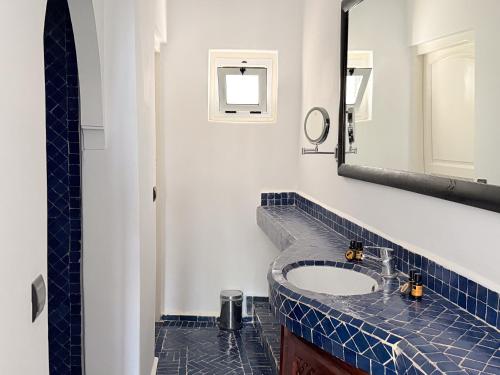 a bathroom with a sink and a mirror at Hôtel Calipau Riad Maison d'Hôtes in Dakhla