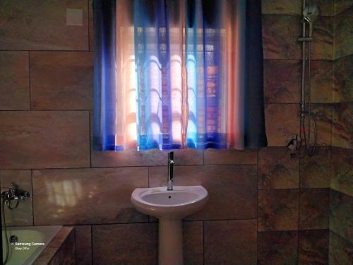 a bathroom with a sink and a window at Dante Guest house in Alberton