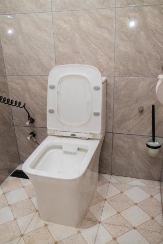 a bathroom with a toilet with the lid up at Summit View Retreat in Moshi