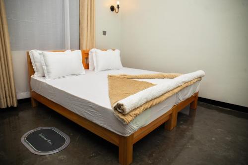 a bed with a blanket on it in a room at Summit View Retreat in Moshi