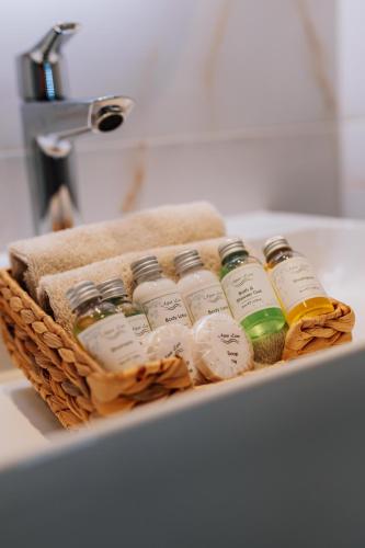 a basket filled with bottles of essential oils on a sink at Aparthotel Jacques van Marken Erfgoed in Delft