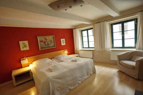 a bedroom with a white bed and a chair at Herberge Zum Sechsten Gebot in Görlitz
