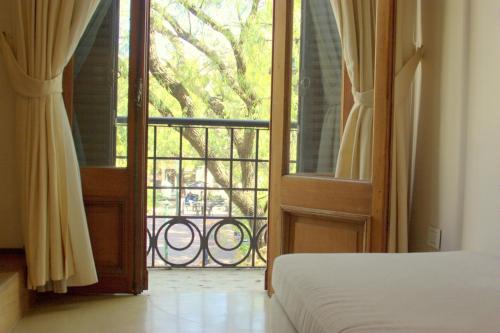 a bedroom with a door open to a balcony at Telmho Hotel Boutique in Buenos Aires