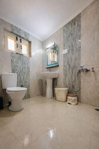 a bathroom with a toilet and a sink at Lidder view resort in Muski