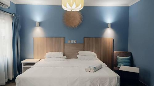 a bedroom with a large bed with a blue wall at Resta Lodge in Kariba