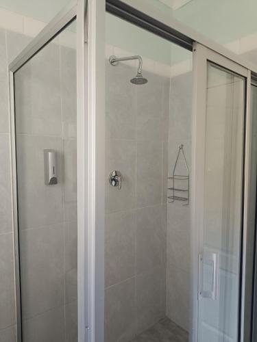a shower with a glass door in a bathroom at Resta Lodge in Kariba