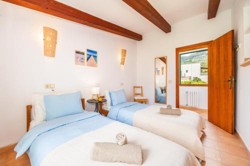 a bedroom with two beds and a window at Ca n'Antonia in Sóller