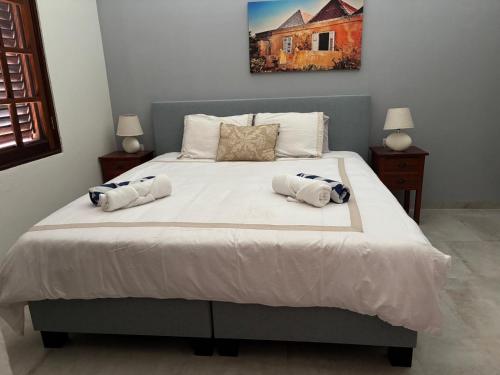 a bedroom with a bed with two towels on it at Tropical Beach Villa with Ocean View in Blue Bay