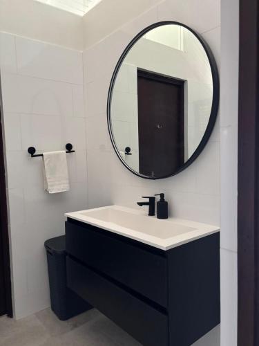 a bathroom with a black and white sink and a mirror at Tropical Beach Villa with Ocean View in Blue Bay