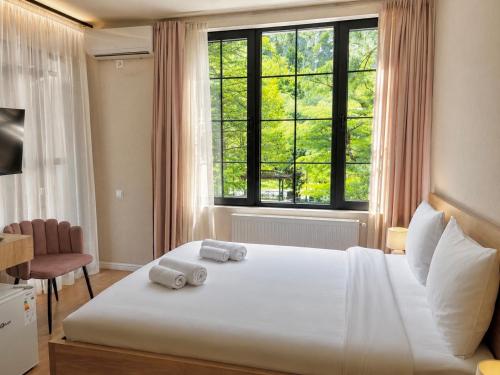 a bedroom with a large bed with two towels on it at Greenwood in Borjomi